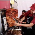 Taquero by Alarmy. A man preparing an Al Pastor taco.