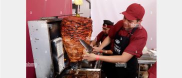 Taquero by Alarmy. A man preparing an Al Pastor taco.